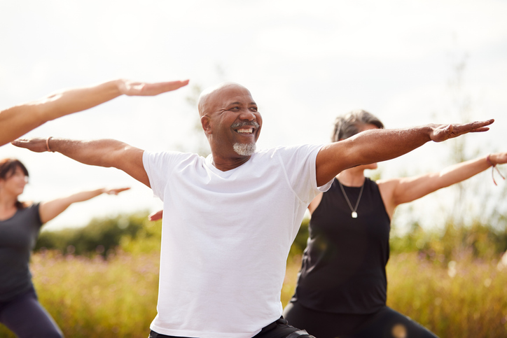 Group Of Mature Men And Women In Class At Outdoor Yoga Retreat Group Of Mature Men And Women In Class At Outdoor Yoga Retreat | PearMD